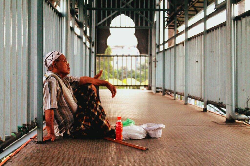 Homem sentado próximo a Grande Mesquita de Medan - dez imagens