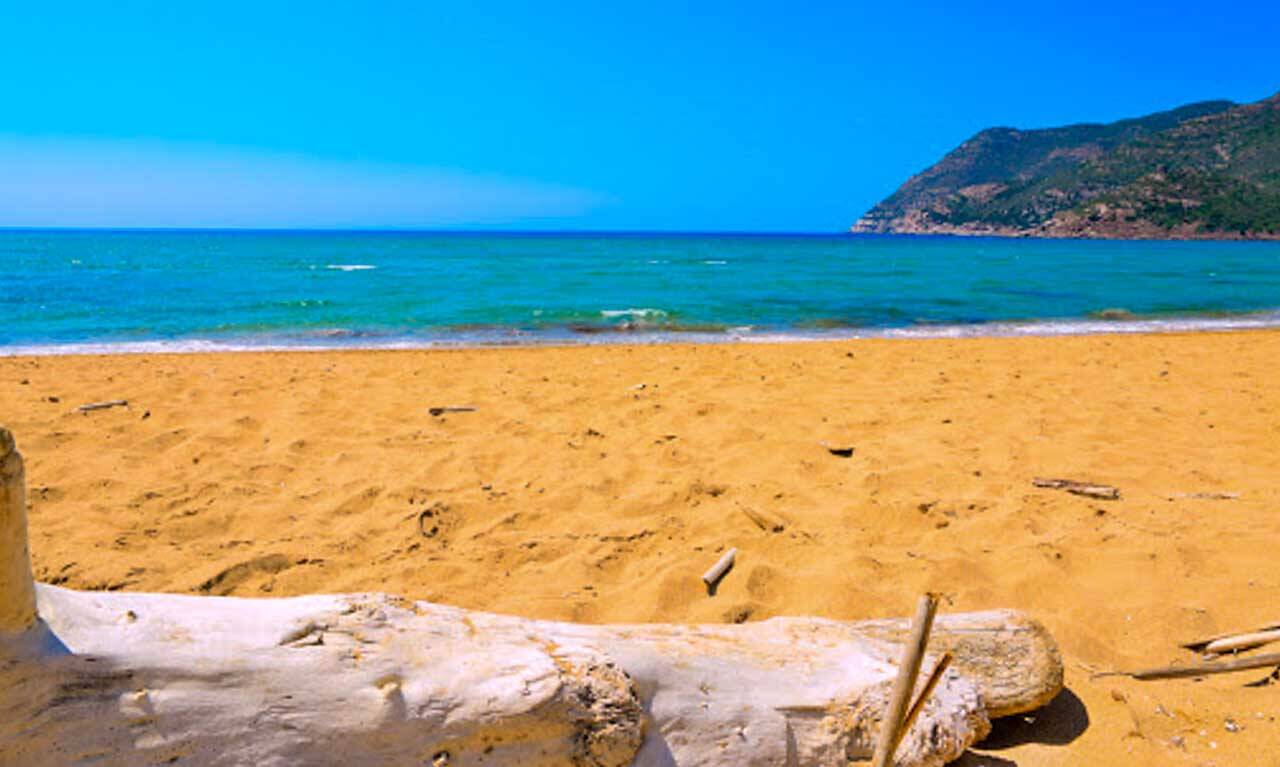 Praia de areia laranja em Porto-Ferro na Sardenha.