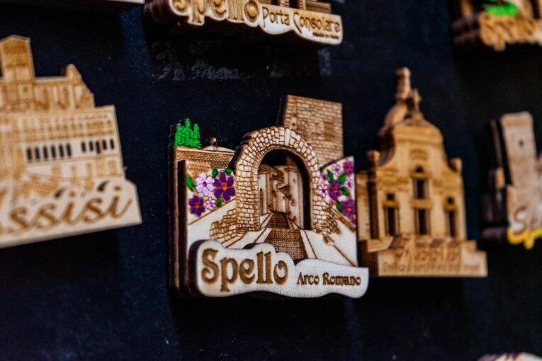 Um souvenir de imã representando o Arco Romano e a cidade de Spello.