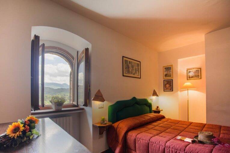 Uma das suítes do Appartamenti In Urbe, com vista para as montanhas em Spello. | Foto: divulgação/booking