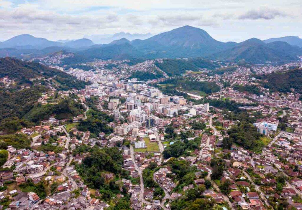 Cidade de Teresópolis vista de cima e as montanhas do Parque dos Três Picos ao fundo. Ônibus SP para Teresópolis