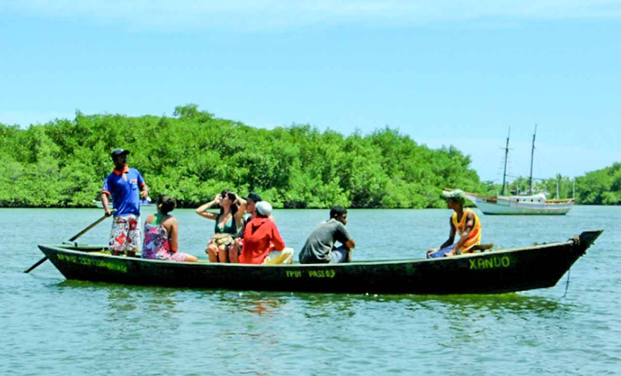 A travessia do portal para chegar em Caraíva na Bahia é feita nessas canoas